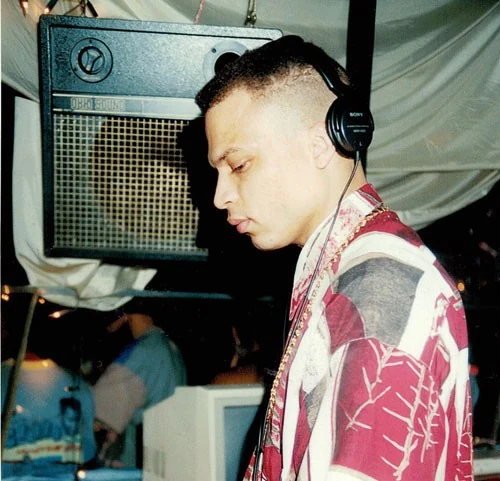 A young DJ Moortje behind the decks with headphones on