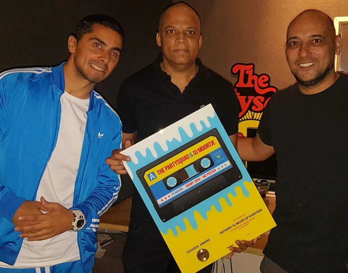 DJ Moortje with The Partysquad holding the gold award for Plakken